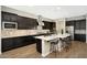 Modern kitchen with dark cabinetry, stainless steel appliances, and an island at 20594 W Pasadena Ave, Buckeye, AZ 85396