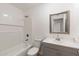 Clean bathroom with gray vanity, tub, and framed mirror at 10452 W Meade Dr, Sun City, AZ 85351