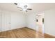 Spacious bedroom with hardwood floors and ceiling fan; view of another room at 10452 W Meade Dr, Sun City, AZ 85351