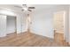 Bright bedroom with wood-look floors, ceiling fan, and mirrored closet at 10452 W Meade Dr, Sun City, AZ 85351