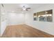 Living room with wood-look floors, a large window, and a ceiling fan at 10452 W Meade Dr, Sun City, AZ 85351
