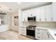 Modern white kitchen with stainless steel appliances and quartz countertops at 10802 E Secret Canyon Rd, Gold Canyon, AZ 85118