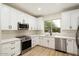 Modern white kitchen with stainless steel appliances and quartz countertops at 10802 E Secret Canyon Rd, Gold Canyon, AZ 85118