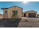 Front view of house featuring a two-car garage, desert landscaping, and attractive facade at 13637 W Hackamore Dr, Peoria, AZ 85383
