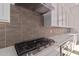 Modern kitchen features gas cooktop, quartz countertops, and sleek cabinetry at 13637 W Hackamore Dr, Peoria, AZ 85383