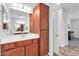 Elegant bathroom with wood cabinets, a large mirror, and an additional linen closet at 36106 N Desert Tea Dr, San Tan Valley, AZ 85140