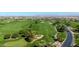 Aerial view showcasing a large green golf course with roads and trees at 36106 N Desert Tea Dr, San Tan Valley, AZ 85140