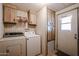 Laundry room with cabinets, built-in shelving, and exterior door at 6960 W Peoria Ave # 125, Peoria, AZ 85345