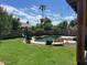 Relaxing kidney shaped pool surrounded by grass and palm trees at 4053 S Skyline Ct, Gilbert, AZ 85297