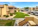 View of apartment building and parking lot with green grass at 3601 W Tierra Buena Ln # 228, Phoenix, AZ 85053