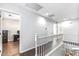 Upstairs hallway with white railing and access to bedrooms at 18533 W Sanna St, Waddell, AZ 85355