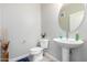 Small bathroom with pedestal sink, toilet, and floating shelves at 2511 W Queen Creek Rd # 205, Chandler, AZ 85248