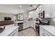 White kitchen features stainless steel appliances and an island with seating at 2511 W Queen Creek Rd # 205, Chandler, AZ 85248
