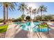 Inviting pool with a waterfall feature and surrounding palm trees at 4548 E Carob Dr, Gilbert, AZ 85298