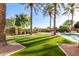 Relaxing pool area with artificial turf and palm trees at 4548 E Carob Dr, Gilbert, AZ 85298