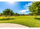 Green grassy park with mature trees and walking path at 43542 W Caven Dr, Maricopa, AZ 85138