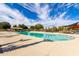 Community pool with surrounding lounge chairs and shade structures at 43542 W Caven Dr, Maricopa, AZ 85138