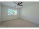 Simple bedroom with ceiling fan and window at 11526 E Milagro Ave, Mesa, AZ 85209