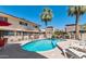 Kidney-shaped community pool with lounge chairs and palm trees at 4848 N Woodmere Fairway -- # 15, Scottsdale, AZ 85251
