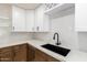 Modern kitchen with a black undermount sink and white cabinets at 4848 N Woodmere Fairway -- # 15, Scottsdale, AZ 85251