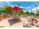 Stone patio with seating area, umbrella, and fire pit at 11305 S 195Th Dr, Buckeye, AZ 85326