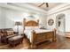 Bright bedroom featuring a king-size bed and wood floors at 11305 S 195Th Dr, Buckeye, AZ 85326