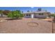 Large backyard with gravel, a mature tree, and a small patio area at 6340 E Boise St, Mesa, AZ 85205