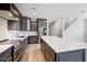 Spacious kitchen featuring dark cabinetry, quartz countertops, and stainless steel appliances at 18151 W Carlota Ln, Surprise, AZ 85387