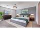 Main bedroom with grey platform bed, large artwork, and ceiling fan at 18151 W Carlota Ln, Surprise, AZ 85387