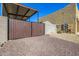 Backyard access with a brown double gate and covered structure at 20324 W Melanie Dr, Wittmann, AZ 85361