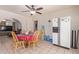 Kitchen with white cabinets, a refrigerator, and a dining area with a red tablecloth at 8151 W Clarendon Ave, Phoenix, AZ 85033