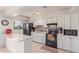 Kitchen with white cabinets, black appliances, and a quartz countertop at 8151 W Clarendon Ave, Phoenix, AZ 85033