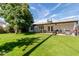 Large backyard with covered patio, grassy area, and mature trees at 8151 W Clarendon Ave, Phoenix, AZ 85033