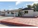 White brick ranch house with a spacious front yard and red brick driveway at 8151 W Clarendon Ave, Phoenix, AZ 85033