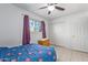 Bright bedroom with double bed, ceiling fan, and ample closet space at 8151 W Clarendon Ave, Phoenix, AZ 85033