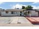 White brick ranch house with a spacious front yard and red brick driveway at 8151 W Clarendon Ave, Phoenix, AZ 85033