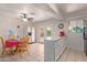 Kitchen with white cabinets, a kitchen island, and a dining area with a red tablecloth at 8151 W Clarendon Ave, Phoenix, AZ 85033