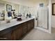 Spa-like bathroom with double sinks, a large mirror, and a walk-in shower at 20640 N Confetti Ct, Maricopa, AZ 85138
