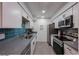 Modern kitchen with stainless steel appliances and blue tile backsplash at 7625 E Camelback Rd # A242, Scottsdale, AZ 85251