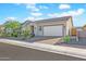 Tan house with desert landscaping and a two-car garage at 17917 W Amberwood Dr, Goodyear, AZ 85338