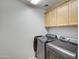 Laundry room with upper cabinets, washer and dryer at 781 E Cowboy Cove Trl, San Tan Valley, AZ 85143