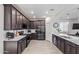 Modern kitchen with dark wood cabinets, white countertops, and stainless steel appliances at 23852 N 167Th Ln, Surprise, AZ 85387