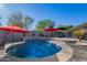 Inviting kidney shaped pool with water feature and red umbrellas at 23852 N 167Th Ln, Surprise, AZ 85387