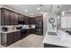 Modern kitchen with dark wood cabinets, white countertops, and stainless steel appliances at 23852 N 167Th Ln, Surprise, AZ 85387