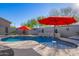 Relaxing kidney shaped pool with water feature and red umbrellas at 23852 N 167Th Ln, Surprise, AZ 85387