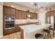 Modern kitchen with wood cabinets, granite island, and stainless steel appliances at 16746 W La Reata Ave, Goodyear, AZ 85395