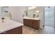 Double vanity bathroom with a large mirror and access to bedroom at 17917 W Amberwood Dr, Goodyear, AZ 85338