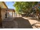 Large backyard with mature trees and a covered patio area at 1018 W Juniper Ave, Gilbert, AZ 85233