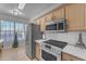 Modern kitchen with stainless steel appliances and light wood cabinets at 14950 W Mountain View Blvd # 1105, Surprise, AZ 85374