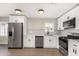 Modern kitchen with white cabinets, hexagon tile, and stainless steel appliances at 1921 E Yale St, Phoenix, AZ 85006